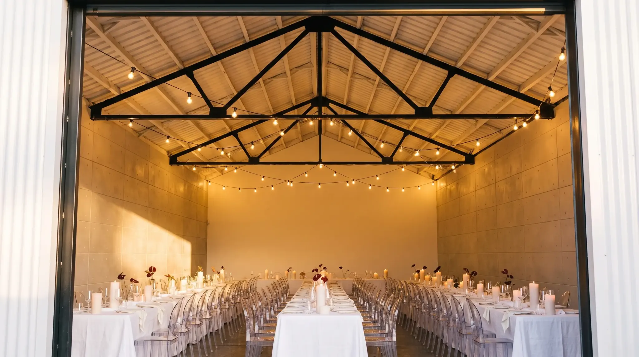 Stepping in at dusk, the lit reception room opening ahead under the gable ceiling